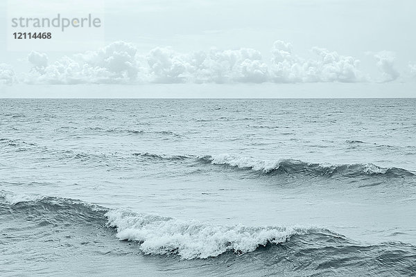 Schwarz-Weiß-Bild von Wellen diagonal zum Bild und einem Band kleiner Kumuluswolken  die direkt über dem Horizont schweben; Ontario  Kanada