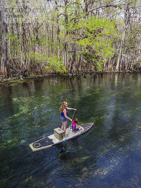 Eine Mutter und ihre Tochter paddeln mit dem Paddelboot den Strom einer Süßwasserquelle hinunter; Chiefland  Florida  Vereinigte Staaten von Amerika