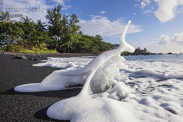 Meeresschaum plätschert am Ufer des schwarzen Sandstrands von Hana; Hana  Maui  Hawaii  Vereinigte Staaten von Amerika