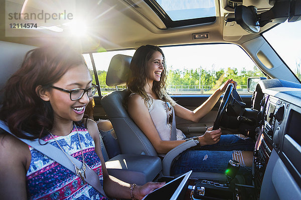 Zwei junge Frauen fahren in einem Auto auf einer Autoreise; Edmonton  Alberta  Kanada