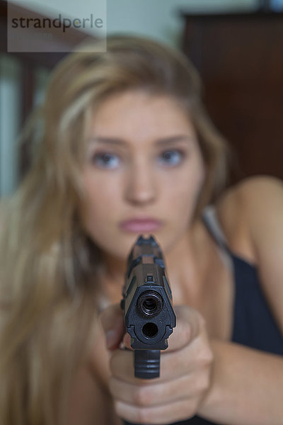 Teenager-Mädchen mit blondem Haar  das eine Waffe auf die Kamera richtet; Connecticut  Vereinigte Staaten von Amerika
