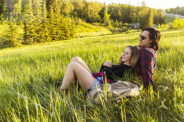 Junges Paar in einem Park  das sich bei einer Herbstwanderung ausruht; Edmonton  Alberta  Kanada