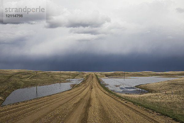 Schotterstraße mit Blick auf einen stürmischen Himmel im Südwesten von Saskatchewan; Val Marie  Saskatchewan  Kanada