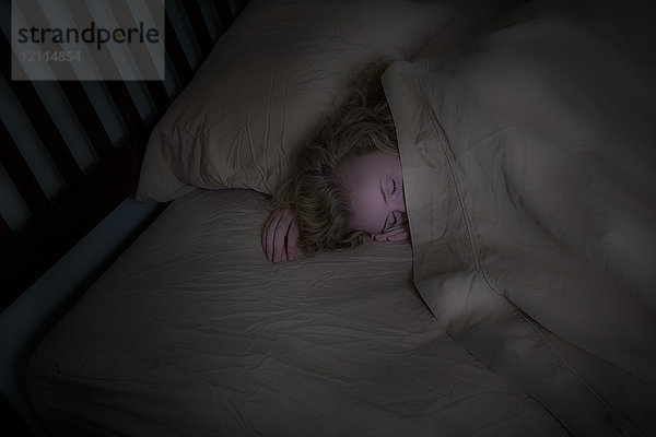 Teenager-Mädchen mit blonden Haaren in ihrem Bett liegend; Connecticut  Vereinigte Staaten von Amerika