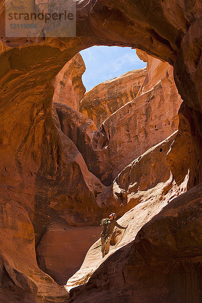 Abenteuersportler im Schoß einer riesigen Slot-Canyon-Schüssel; Hanksville  Utah  Vereinigte Staaten von Amerika