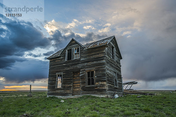 Verlassenes Haus in der Prärie mit Sturmwolken über dem Kopf bei Sonnenuntergang; Val Marie  Saskatchewan  Kanada