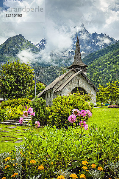 Les Praz de Chamonix  mittelalterliche Kirche und Blumengarten mit der Aiguille Dru im Hintergrund; Chamonix-Mont-Blanc  Haute-Savoie  Frankreich