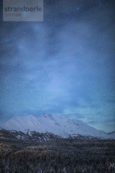 Das schwache Glühen der Aurora Borealis am Nachthimmel beleuchtet die spärlichen Wolken über dem Moose Pass  Kenai-Halbinsel  Süd-Zentral-Alaska; Moose Pass  Alaska  Vereinigte Staaten von Amerika
