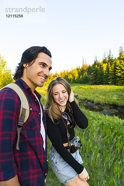 Junges Paar  das im Herbst zusammen in einem Stadtpark spazieren geht und dabei eine Kamera mitnimmt; Edmonton  Alberta  Kanada