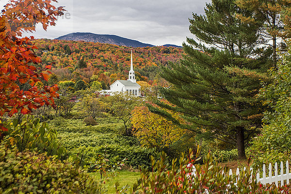 Stowe Church  umgeben von üppigem  herbstlich gefärbtem Laub und Wäldern am Berghang; Stowe  Vermont  Vereinigte Staaten von Amerika