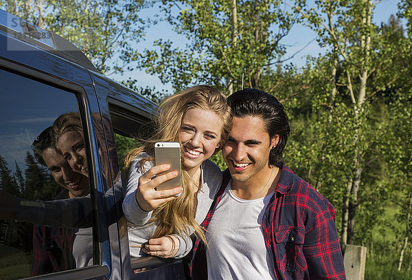 Ein junges Paar  das ein Selbstporträt mit seinem Smartphone in seinem Fahrzeug aufnimmt; Edmonton  Alberta  Kanada