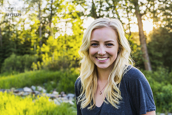 Porträt einer jungen Frau mit langen blonden Haaren in einem Park im Herbst; Edmonton  Alberta  Kanada