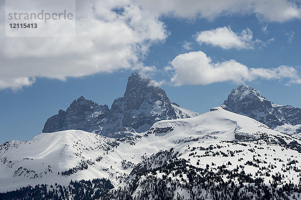 Schroffe Berggipfel in einer verschneiten Landschaft mit blauem Himmel und Wolken  Peace Park; Wyoming  Vereinigte Staaten von Amerika