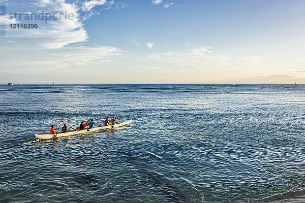 Touristen paddeln in einem Auslegerkanu am Strand von Waikiki; Waikiki  Oahu  Hawaii  Vereinigte Staaten von Amerika