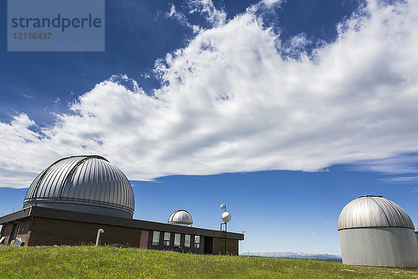 Kuppeln des Astrophysikalischen Observatoriums mit dramatischen Wolken und blauem Himmel  südwestlich von Calgary; Alberta  Kanada
