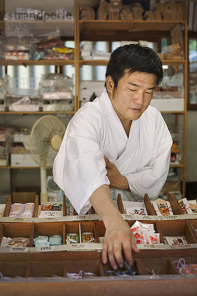 Verkäufer in weißem Kimono im Shinto Sakurai-Schrein  Fukuoka  Japan.
