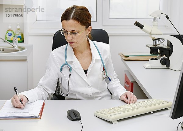Ärztin bei der Arbeit an ihrem Schreibtisch
