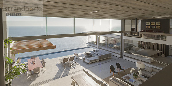 Erhöhte Aussicht  modernes  luxuriöses Haus mit Innenwohnzimmer und Terrasse mit sonnigem Meerblick