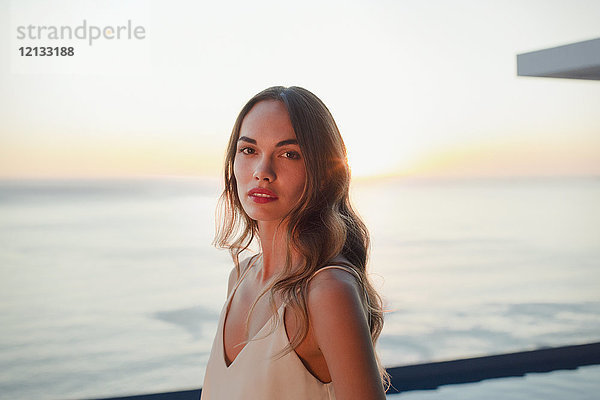 Porträt ernst  schöne Frau auf Luxus-Terrasse mit Blick auf den Sonnenuntergang Meer
