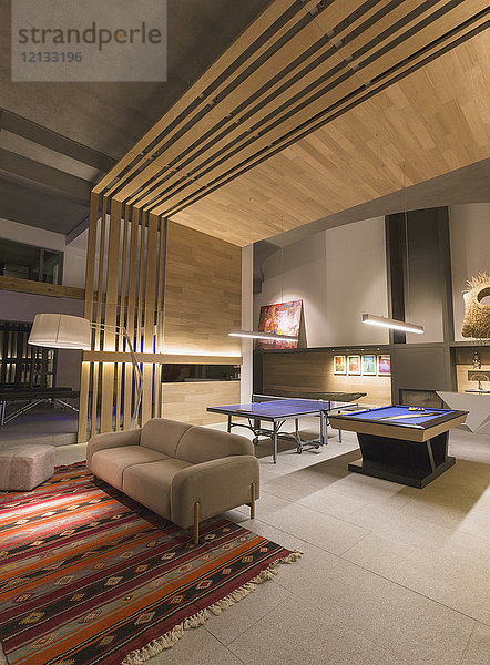 Beleuchtetes  modernes  luxuriöses Haus mit einem Spielzimmer mit Billardtisch und Tischtennisplatte