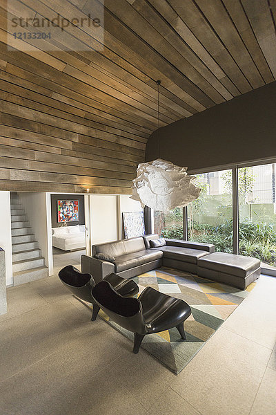 Moderner Kronleuchter in einem luxuriösen Wohnzimmer mit Holzbalkendecke