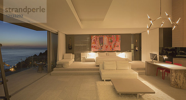 Beleuchtetes modernes  luxuriöses Musterhaus mit Schlafzimmer und Meerblick