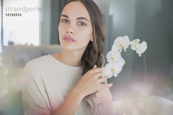 Portrait ernste  schöne brünette Frau mit Händen im Haar