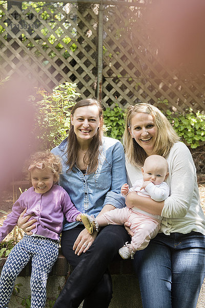 Porträt von lächelnden kaukasischen Müttern und Töchtern im Garten