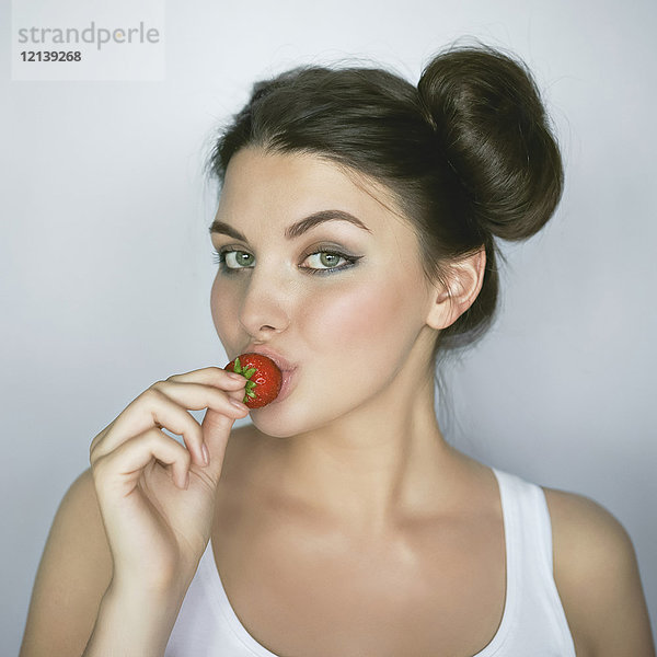 Kaukasische Frau küsst Erdbeere