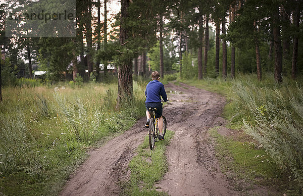 Kaukasische Teenager-Jungen fahren Fahrrad im Wald