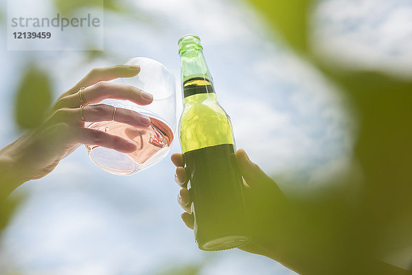 Frauen stoßen mit Bier und Wein an