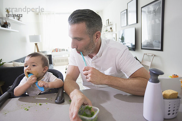 Vater beobachtet seinen kleinen Sohn beim Essen