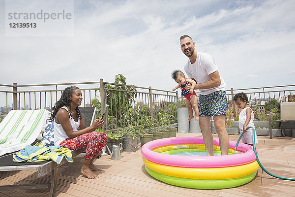 Eltern spielen mit Kindern im aufblasbaren Schwimmbecken