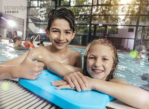Porträt eines lächelnden Jungen und Mädchens im Schwimmbad