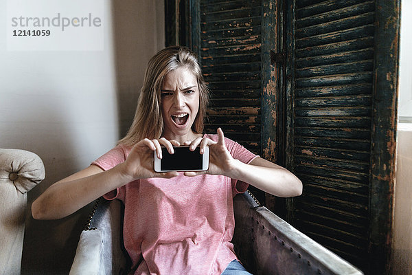 Schreiende junge Frau nimmt Smartphone Selfie