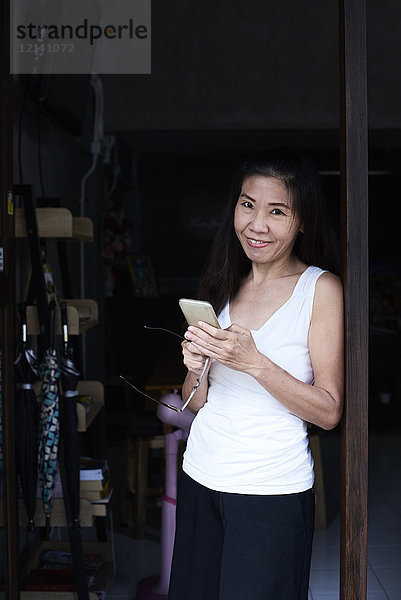 Porträt der lächelnden Frau mit Handy