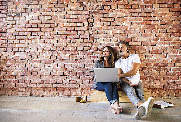Geschäftsmann und Frau im Loft sitzend  mit Laptop  Gründung eines Start-up-Unternehmens