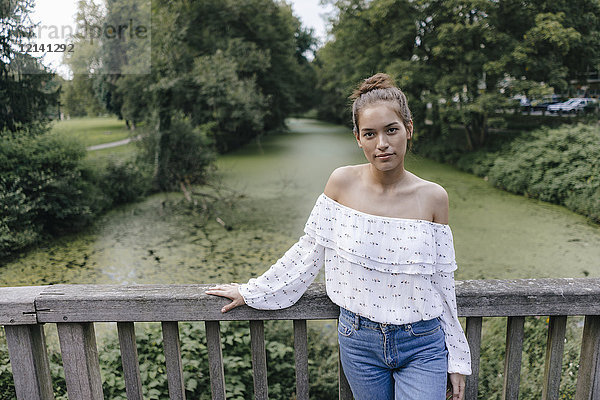 Porträt einer jungen Frau auf einer Brücke stehend