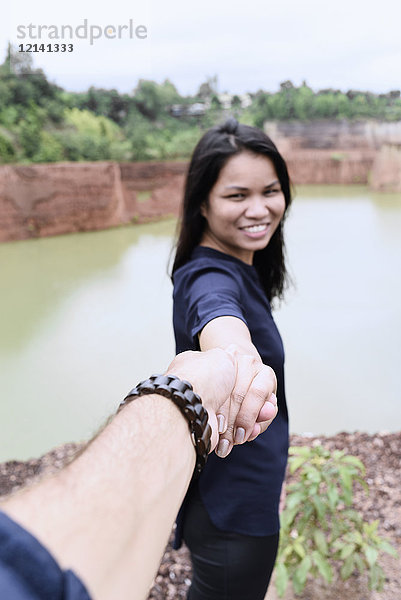 Thailand  Chiang Mai  glückliche junge Frau hält Hand ihres Partners am Grand Canyon