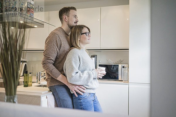 Liebevolles Paar steht in der Küche zu Hause