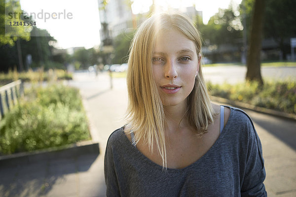 Porträt einer blonden jungen Frau im Gegenlicht