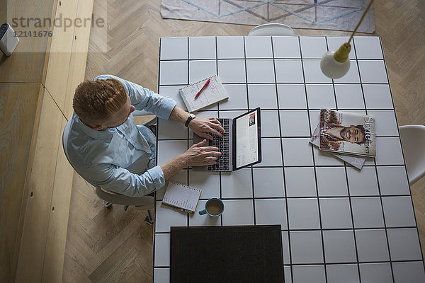 Freiberuflicher Geschäftsmann  der zu Hause an seinem Laptop arbeitet.