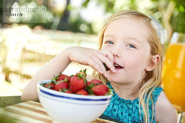 Porträt eines Mädchens  das Erdbeeren isst