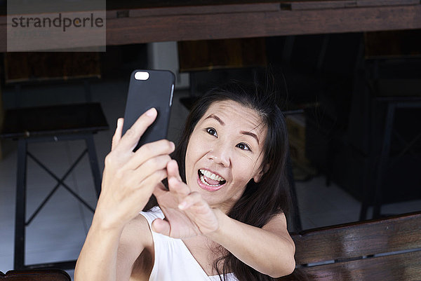 Glückliche Frau nimmt einen Selfie mit Smartphone