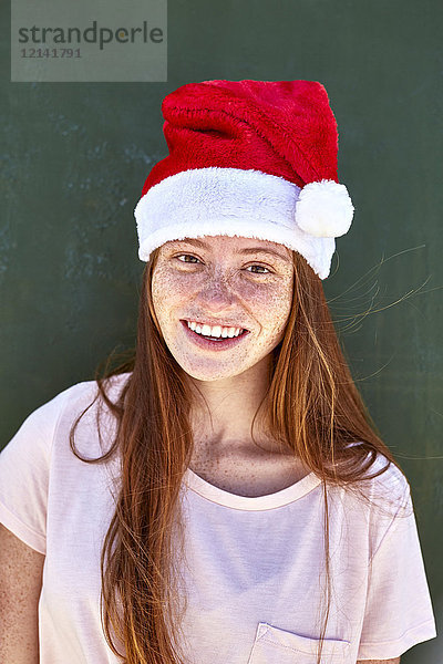 Porträt einer lächelnden jungen Frau mit Weihnachtshut