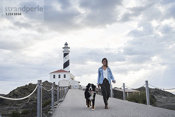 Spanien  Menorca  Berner Sennenhund mit seinem Besitzer im Freien auf dem Leuchtturm