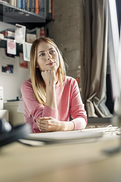Porträt einer jungen Frau  die zu Hause am Schreibtisch arbeitet
