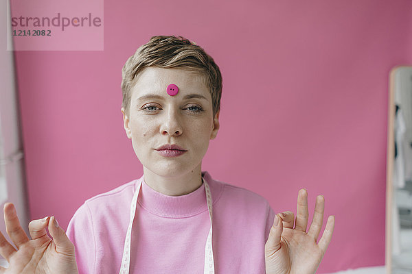 Porträt der Schneiderin mit rosa Knopf an der Stirn