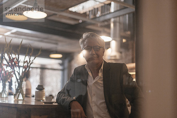 Porträt eines älteren Geschäftsmannes bei einer Pause in einem Cafe