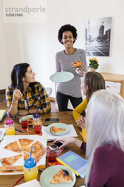 Gruppe junger Frauen zu Hause beim Lernen und Pizza essen